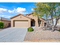 Tan house with a two-car garage and desert landscaping at 41432 N Bent Creek Way, Phoenix, AZ 85086