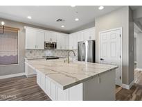 Kitchen island with white cabinets and a large quartz countertop at 41432 N Bent Creek Way, Phoenix, AZ 85086