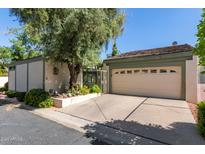 Attached home's two-car garage is front-facing and features mature landscaping on a sunny day at 8101 N Central Ave # 6, Phoenix, AZ 85020