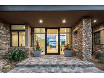 Inviting front entrance with stone accents, modern lighting, and large glass doors at 40575 N 109Th Pl, Scottsdale, AZ 85262