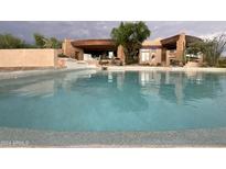 Inviting pool with cool, refreshing water and views of the stone-accented exterior of this desert home at 9853 E Sundance Trl, Scottsdale, AZ 85262
