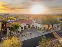 Expansive desert home boasting a red tile roof, circular driveway, and stunning sunset views at 10721 E La Junta Rd, Scottsdale, AZ 85255