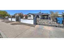 Charming front yard view featuring an ornate metal gate and decorative wall at 2124 W Maricopa St, Phoenix, AZ 85009