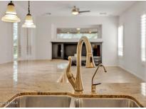 Bright kitchen featuring a stainless steel sink, gold faucet, and stone countertops at 13055 W Eagle Talon Trl, Peoria, AZ 85383