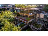 Aerial view of a modern multi-level building with lush landscaping and private balconies at 7117 E Rancho Vista Dr # 4006, Scottsdale, AZ 85251