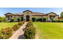 Charming single-story home featuring a stone facade, tile roof, manicured lawn, and inviting landscape at 19575 E Vallejo St, Queen Creek, AZ 85142
