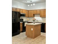 Modern kitchen with island, stainless steel appliances, and ample cabinetry at 1718 W Colter St # 195, Phoenix, AZ 85015