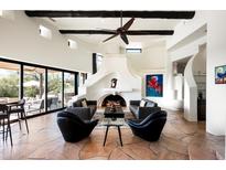 Bright living room featuring high ceilings, a unique fireplace, and seamless indoor-outdoor flow at 42035 N 113Th Way, Scottsdale, AZ 85262