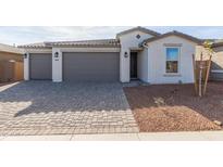 Two-car garage and front yard with paved driveway at 17845 W Blue Sky Dr, Surprise, AZ 85387