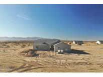 Newly constructed single-story home featuring modern architecture and neutral stucco, set against a desert backdrop at 25721 W Running Deer Trl, Wittmann, AZ 85361