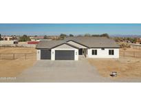 New construction home with two-car garage and desert landscaping at 25721 W Running Deer Trl, Wittmann, AZ 85361