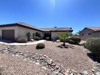 Charming single-story home featuring a low-maintenance desert landscape with decorative rocks and a pathway to the front door at 18326 N Gila Springs Dr, Surprise, AZ 85374