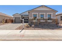Charming single-story home showcasing a stone and stucco exterior with a well-manicured front yard at 12003 W Parkway Ln, Avondale, AZ 85323