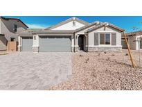 Charming single-story home with a three-car garage, stone accents, and low-maintenance landscaping at 12314 W Marguerite Ave, Avondale, AZ 85323