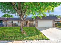 Brick ranch home with attached garage and grassy yard at 9613 W Shasta Dr, Sun City, AZ 85351