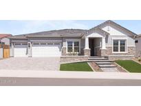 Charming single-story home featuring a three-car garage, stone accents, and a well-manicured lawn at 19964 W Marshall Ave, Litchfield Park, AZ 85340