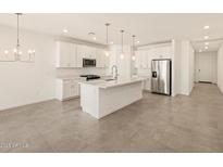 Modern kitchen with white cabinets, stainless steel appliances, and an island at 37422 W San Clemente St, Maricopa, AZ 85138