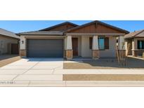 Charming single-story home with stone accents, a gray garage door, and a well-manicured front yard at 20542 N 226Th Ln, Surprise, AZ 85387