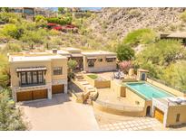 Stunning home exterior showcasing a beautiful pool, lush landscaping, and attached garages on a sunny day at 7002 N Hillside Dr, Paradise Valley, AZ 85253