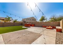 Inviting backyard featuring a built-in BBQ, fire pit, string lights, and artificial turf for entertaining at 272 N 167Th Ln, Goodyear, AZ 85338