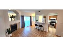 Bright living room with hardwood floors, fireplace, and kitchen bar at 930 N Mesa Dr # 1003, Mesa, AZ 85201