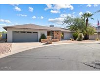 Charming single-story home featuring a manicured front yard with desert landscaping, a grey garage door and a stone mailbox at 9039 N Concho Ln, Phoenix, AZ 85028