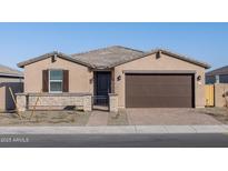 Single-story home with brown garage door and landscaped front yard at 17756 W Coolidge St, Goodyear, AZ 85395