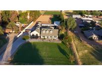 Aerial view of a single-Gathering home with expansive green lawns, and equestrian facilities at 7207 N 175Th Ave, Waddell, AZ 85355