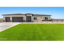 Charming single-story home with a well-manicured lawn, two-car garage, and desert-style landscaping at 18083 W Amber Dr, Goodyear, AZ 85338