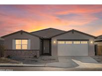 One-story home with a two-car garage, neutral color palette, and landscaping at 36893 W La Paz St, Maricopa, AZ 85138