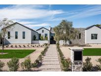 Stunning single Gathering home featuring xeriscaping, natural stone, and green lawn at 9810 N 57Th St, Paradise Valley, AZ 85253