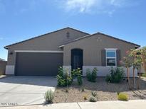 Charming single-story home with desert landscaping, a modern two car garage and covered front porch at 20357 N 225Th Dr, Surprise, AZ 85387