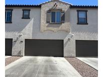 View of a two-story home with a pair of dark gray garages and beautiful white stucco at 155 N Lakeview Blvd # 268, Chandler, AZ 85225