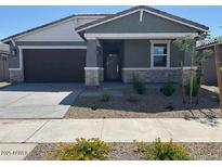 Charming single-story home featuring a stone accent facade and a two-car garage at 20331 N 225Th Dr, Surprise, AZ 85387