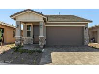 Charming single-story home with stone accents, a two-car garage, and a paved driveway at 5678 N 205Th Ln, Buckeye, AZ 85396