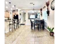 Open dining area featuring tile flooring, a black dining set, and views to the kitchen and living area at 901 W Witt Ave, Queen Creek, AZ 85140