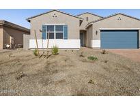 Charming single-story home with a gravel front yard and blue accents on the garage and window shutters at 17654 W Pierson St, Goodyear, AZ 85395