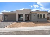 Charming single-story home boasting a modern elevation with a 2-car garage and desert landscaping at 4799 W Flat Iron Ct, Queen Creek, AZ 85144