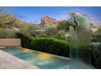 The backyard features a pool and sculpture with stunning desert mountain views at 6301 N 51St Pl, Paradise Valley, AZ 85253