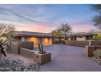 Beautiful home exterior with a spacious driveway, desert landscaping, and a two-car garage under a colorful sky at 9216 E Sky Line Dr, Scottsdale, AZ 85262