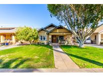 Charming bungalow with a well-manicured lawn and mature landscaping at 38 W Lynwood St, Phoenix, AZ 85003
