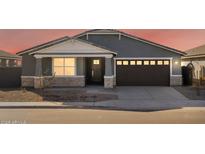 Gray house with brown garage door, stone accents, and landscaping at 36933 W La Paz St, Maricopa, AZ 85138