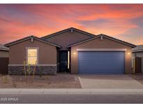 Beautiful single-story home with a two-car garage, stone accents, and desert landscaping at sunset at 4323 W Josephine St, San Tan Valley, AZ 85144