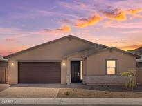 Charming single-story home with a brick driveway, two-car garage, and desert landscaping against a beautiful twilight sky at 4919 W Hunter Trl, San Tan Valley, AZ 85144