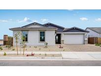 Charming single-story home with a well-manicured front yard, large windows, and a two-car garage at 25149 N 171St Ave, Surprise, AZ 85387