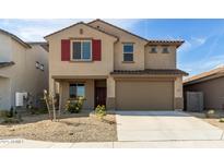 Two-story home featuring red shutters and a two car garage with desert landscaping at 8552 N 170Th Ln, Waddell, AZ 85355