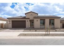 Charming single-story home featuring a tile roof, desert landscaping, and a two-car garage at 829 W Golden Ore Pass, Apache Junction, AZ 85120
