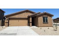 Single-story home featuring an attached two-car garage, a neutral color scheme, and minimal landscaping at 24592 W St Anne Ave, Buckeye, AZ 85326