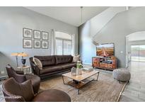 Inviting living room with vaulted ceilings, a brown leather sofa, and abundant natural light at 8708 S 50Th Ln, Laveen, AZ 85339