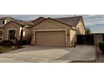 Tan two-story house with a two-car garage and desert landscaping at 1311 W Windsong Dr, Phoenix, AZ 85045
